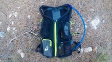 El tubo sale por un agujero que está en una de las asas en las Asics Fujitrail Speed Backpack.